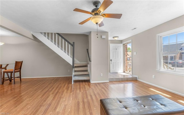 foyer entrance with a ceiling fan, baseboards, visible vents, and light wood-type flooring