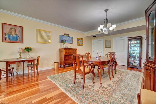 dining area with a chandelier, crown molding, light wood-type flooring, and baseboards