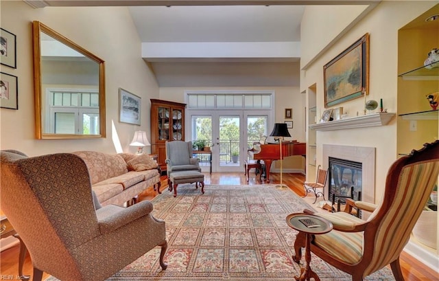living room with lofted ceiling, wood finished floors, and a glass covered fireplace