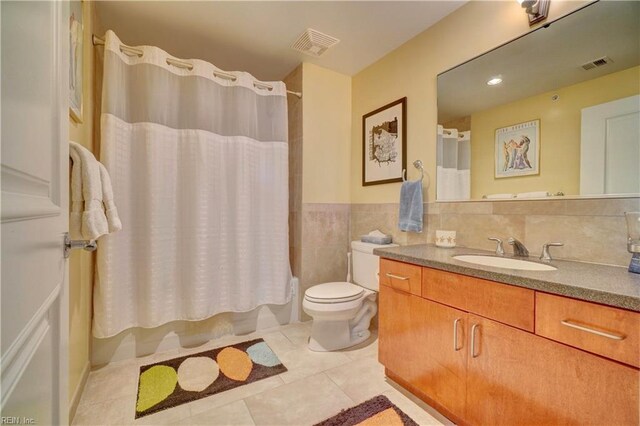 bathroom featuring tile patterned floors, vanity, toilet, and shower / tub combo with curtain