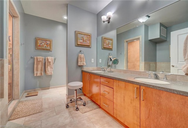 bathroom with tile patterned floors, double vanity, an enclosed shower, and baseboards