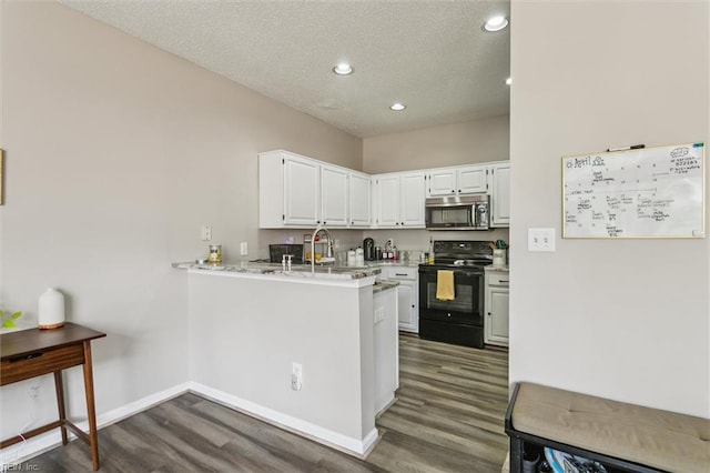 kitchen with electric range, white cabinets, stainless steel microwave, dark wood-style floors, and recessed lighting