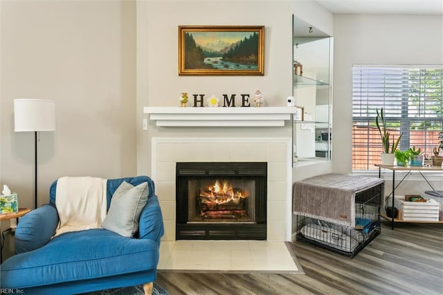 sitting room with wood finished floors and a tile fireplace