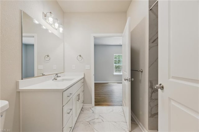 full bath with baseboards, marble finish floor, and vanity