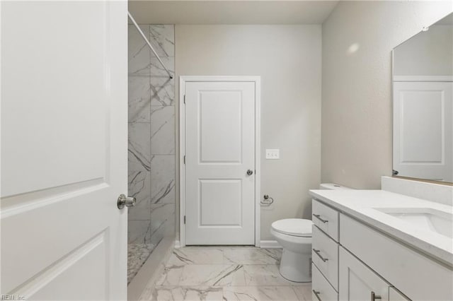 full bath with toilet, a marble finish shower, marble finish floor, and vanity