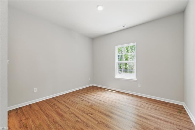 spare room with baseboards, visible vents, and light wood-style flooring