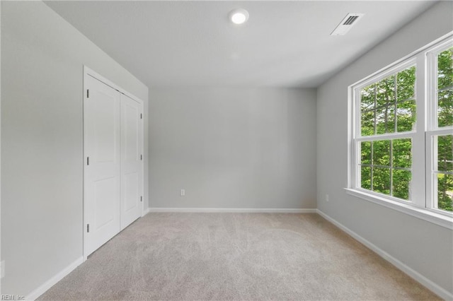 unfurnished room featuring baseboards, plenty of natural light, and light colored carpet