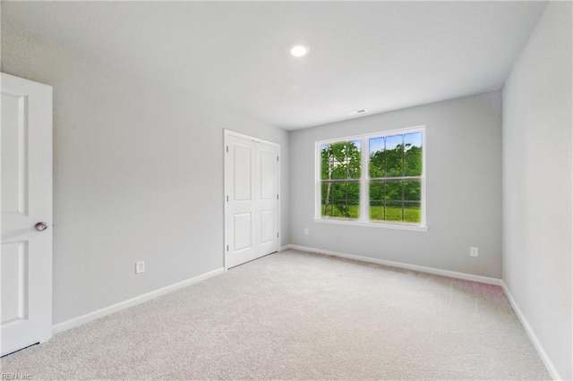 unfurnished bedroom with recessed lighting, baseboards, carpet, and a closet