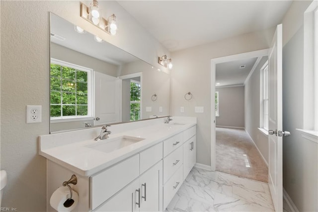bathroom featuring double vanity, baseboards, a sink, and marble finish floor