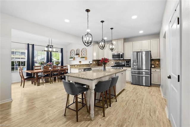 kitchen with an inviting chandelier, light wood-style floors, recessed lighting, tasteful backsplash, and stainless steel appliances