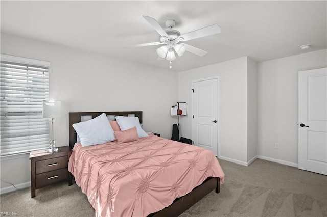 bedroom featuring baseboards, ceiling fan, and light colored carpet