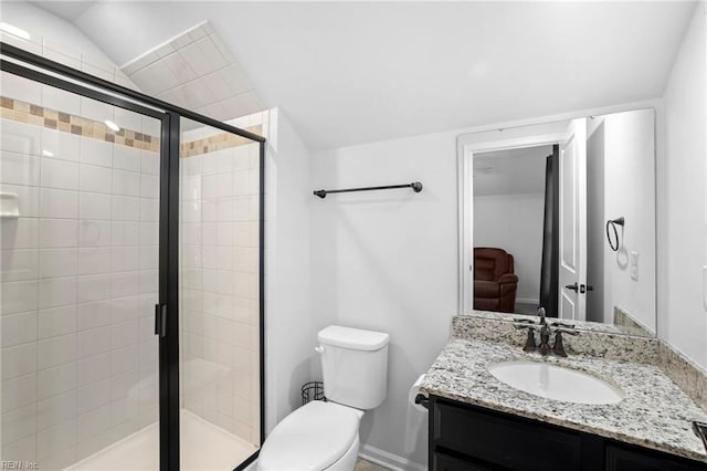 bathroom with vaulted ceiling, a stall shower, vanity, baseboards, and toilet