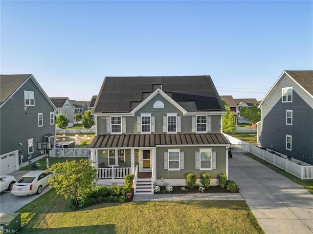 view of front of property featuring a front lawn, covered porch, a standing seam roof, metal roof, and solar panels