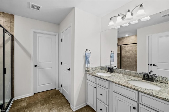 bathroom with visible vents, a sink, a stall shower, and double vanity