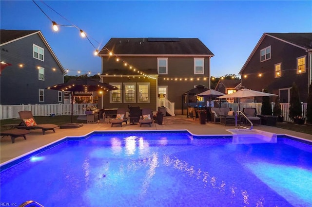 rear view of property with a patio, fence, an outdoor hangout area, and a fenced in pool