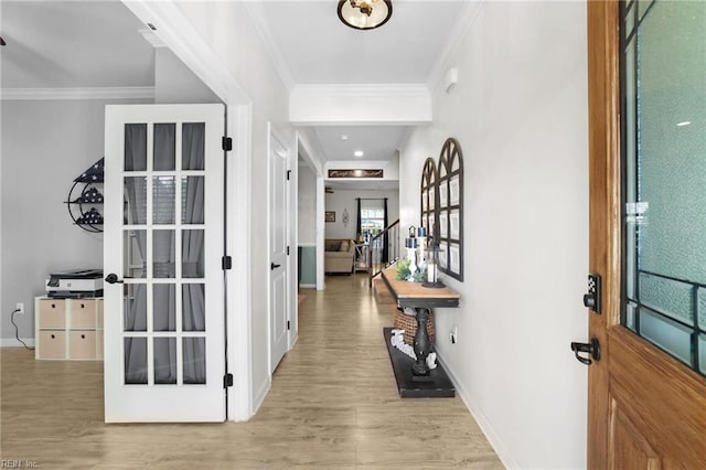 foyer with baseboards, ornamental molding, and wood finished floors