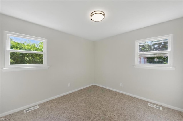 carpeted empty room with baseboards and visible vents