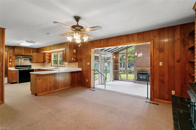 1365 Old Buckroe Rd, Hampton, VA 23663 - kitchen featuring range with gas stovetop, under cabinet range hood, wood walls, and brown cabinetry