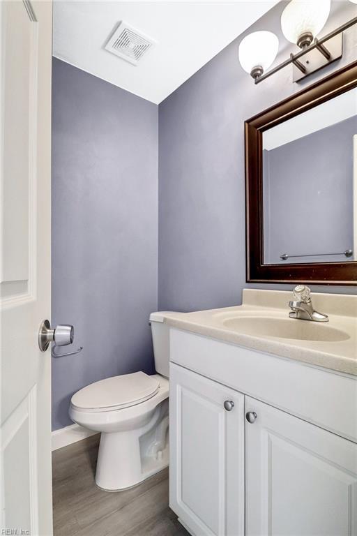 2100 Ruth St, Chesapeake, VA 23324 - bathroom featuring vanity, toilet, wood finished floors, and baseboards