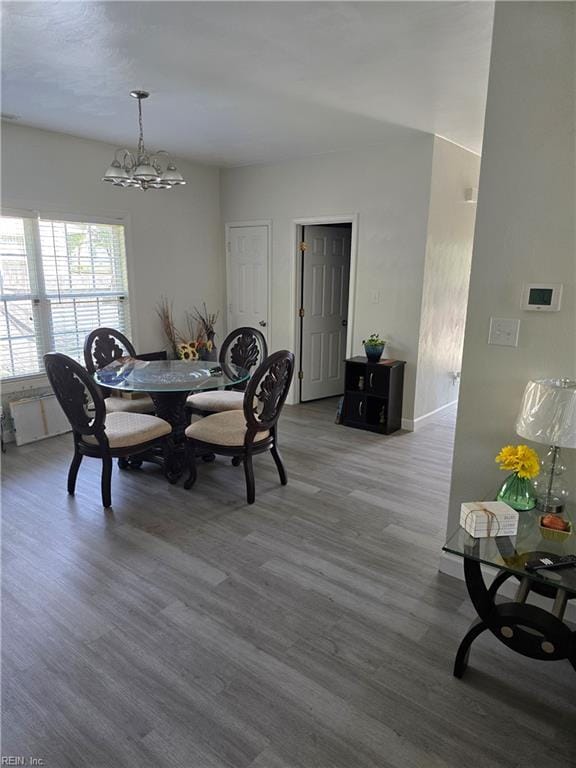 dining area with an inviting chandelier and wood finished floors