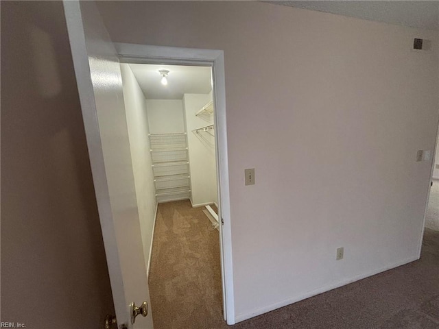hall with baseboards and carpet flooring