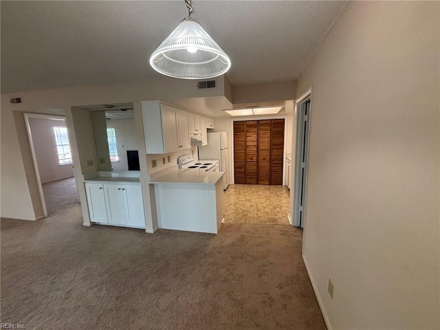 kitchen with carpet flooring, white cabinetry, and visible vents