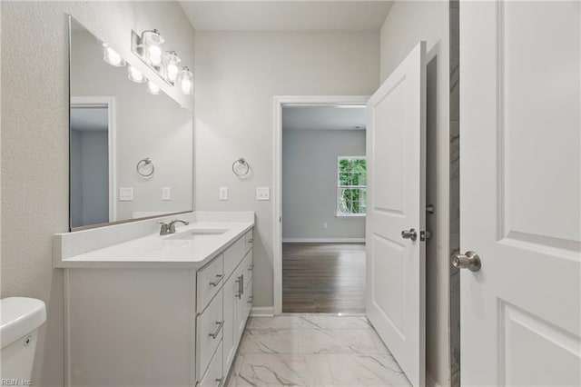 bathroom featuring vanity, baseboards, toilet, and marble finish floor