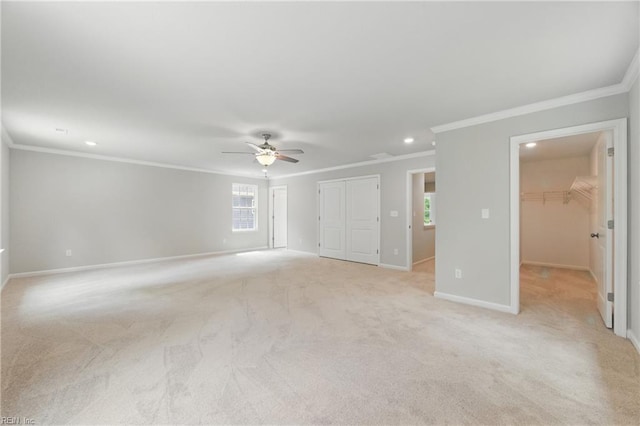 interior space featuring ceiling fan, light colored carpet, crown molding, baseboards, and recessed lighting