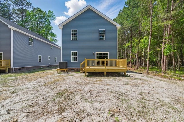 rear view of house with a wooden deck, cooling unit, and crawl space