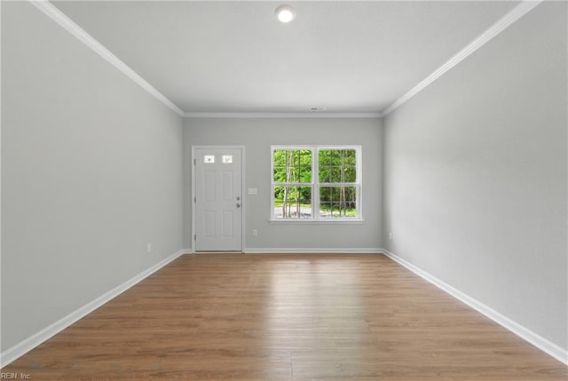 interior space with baseboards, ornamental molding, and wood finished floors