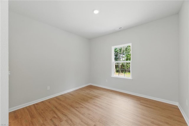 empty room featuring light wood-style floors, recessed lighting, and baseboards
