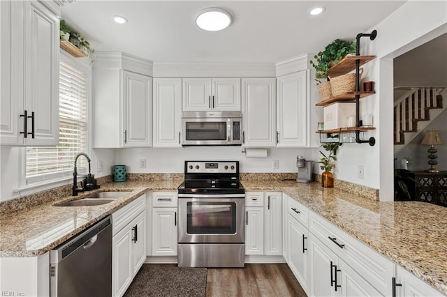 kitchen with a sink, plenty of natural light, open shelves, and stainless steel appliances