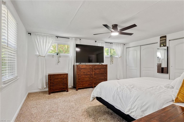 carpeted bedroom with baseboards, multiple windows, and ceiling fan