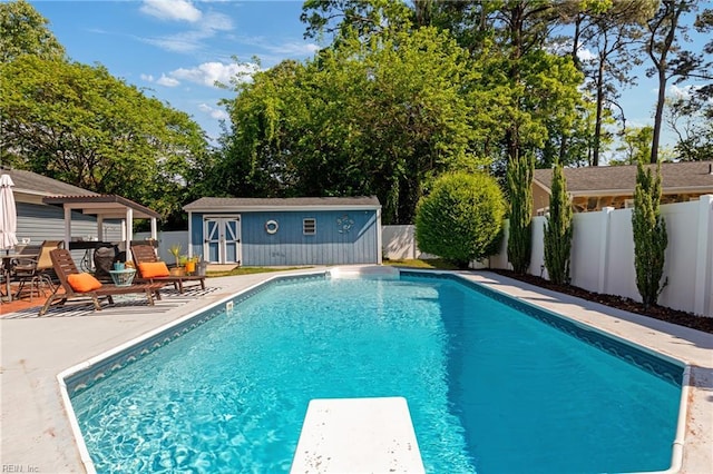 view of swimming pool with an exterior structure, an outdoor structure, a fenced backyard, and a patio area
