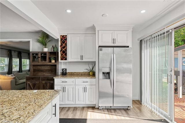 kitchen with light wood-style floors, stainless steel refrigerator with ice dispenser, recessed lighting, white cabinetry, and light stone counters
