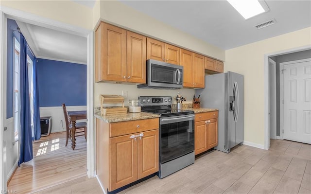 kitchen featuring visible vents, light stone countertops, light wood-style floors, baseboards, and appliances with stainless steel finishes