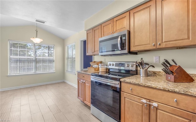 kitchen featuring visible vents, lofted ceiling, light stone countertops, baseboards, and appliances with stainless steel finishes