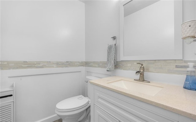 half bath featuring vanity and toilet