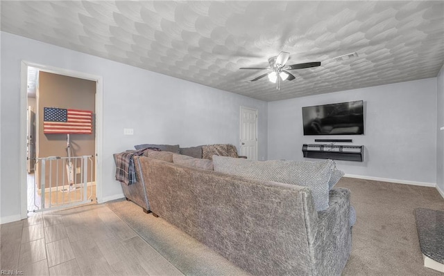 living room featuring a ceiling fan, baseboards, and visible vents