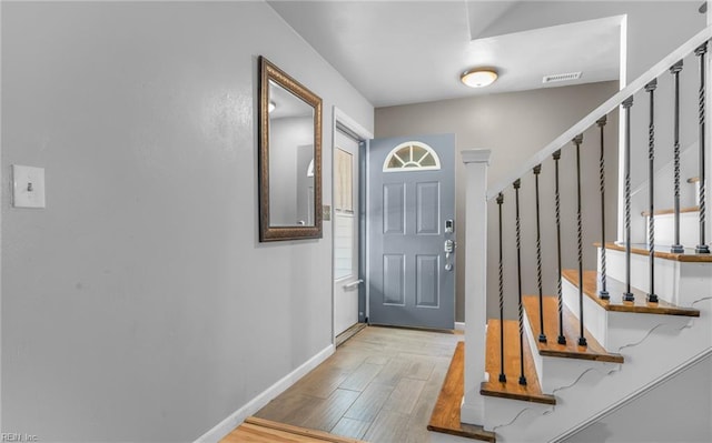 interior space featuring baseboards, light wood-style flooring, stairs, and visible vents