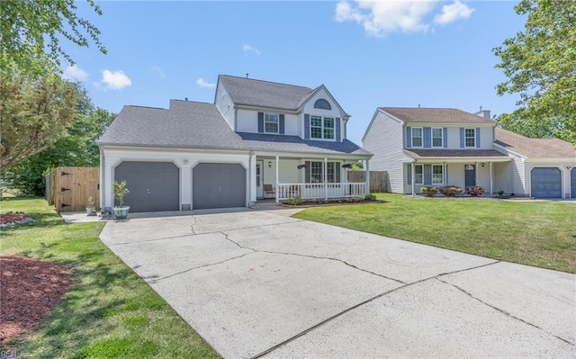 traditional home with an attached garage, a front yard, a chimney, concrete driveway, and a porch
