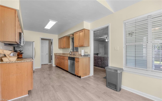 kitchen with baseboards, a sink, light wood-style flooring, and appliances with stainless steel finishes