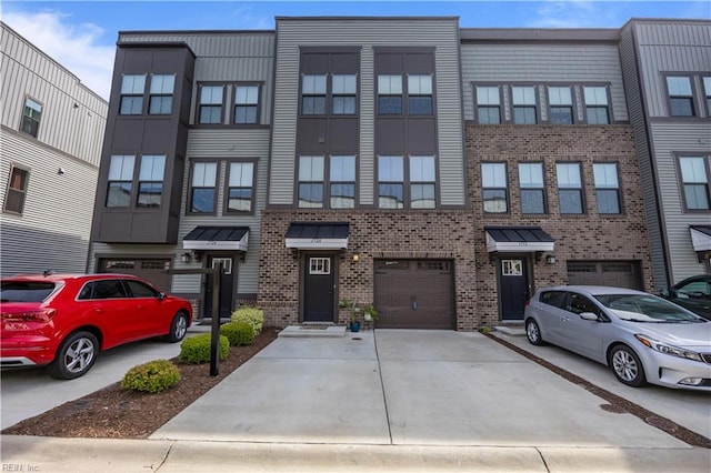 view of front of property featuring concrete driveway, brick siding, and an attached garage