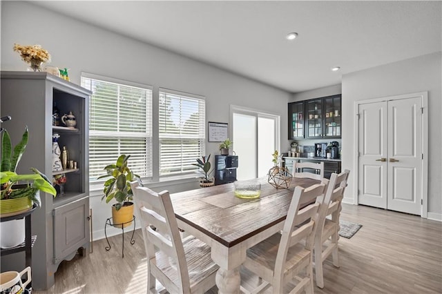 dining area with baseboards, light wood-style flooring, and recessed lighting