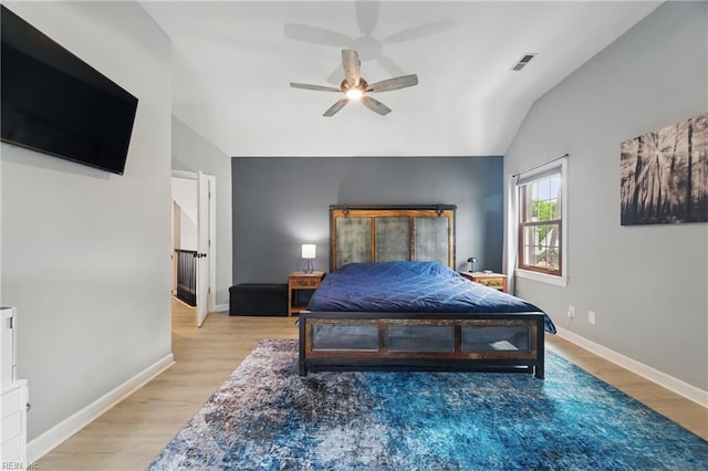 bedroom featuring light wood-style floors, baseboards, a ceiling fan, and vaulted ceiling