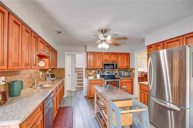 kitchen featuring visible vents, decorative backsplash, ceiling fan, a sink, and appliances with stainless steel finishes