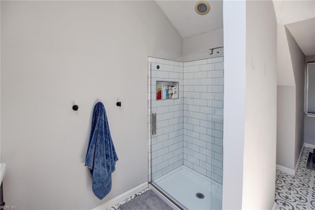 full bathroom featuring baseboards, vaulted ceiling, and a shower stall