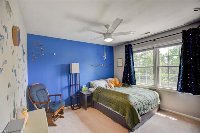carpeted bedroom featuring baseboards, visible vents, and ceiling fan