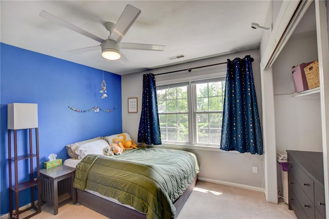 carpeted bedroom with baseboards, a ceiling fan, and visible vents