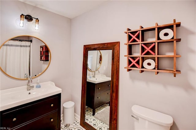 full bath with a sink, toilet, and two vanities